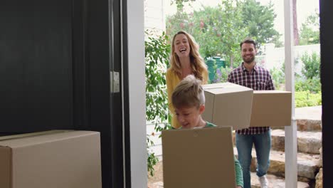 family with cardboard, boxes entering in a comfortable home 4k