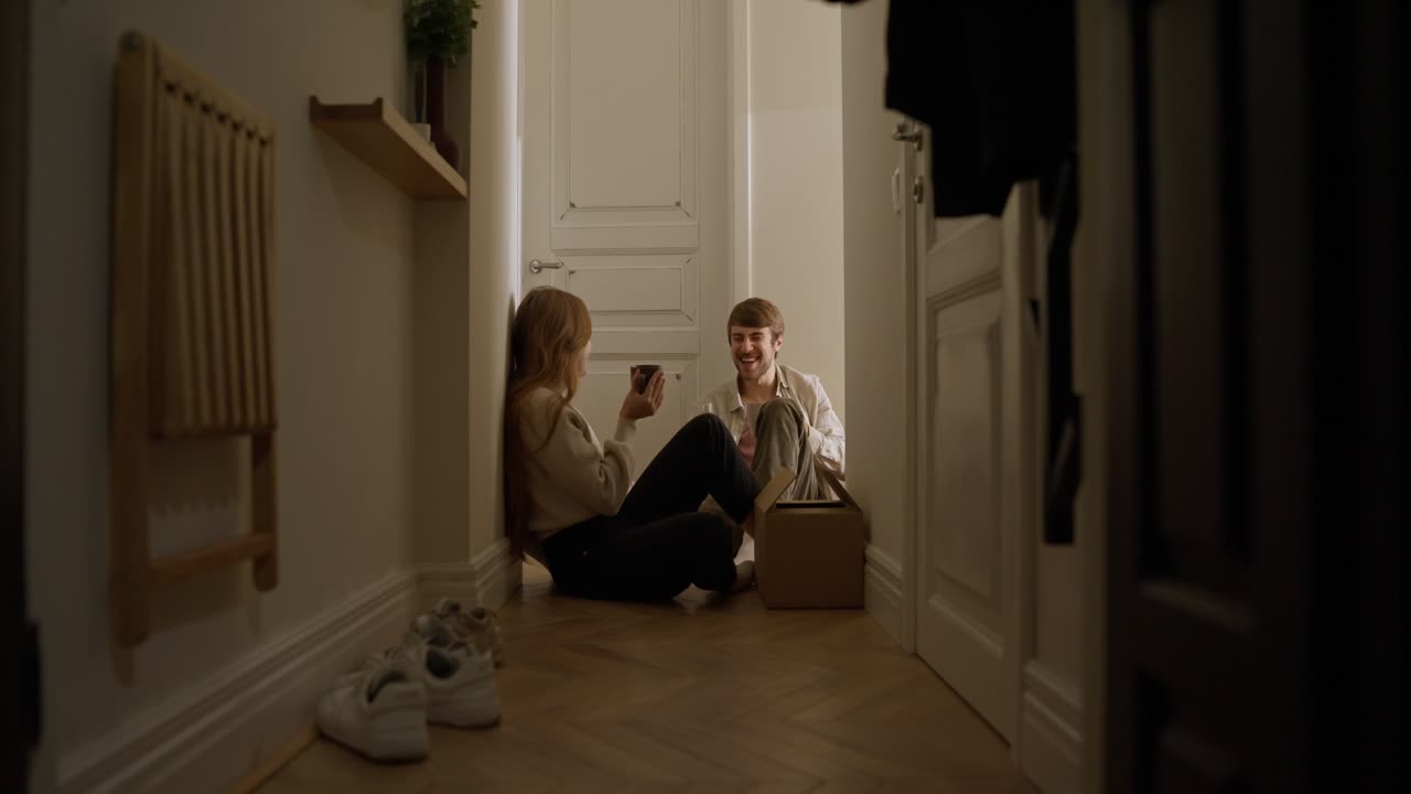 pareja relajándose en un pasillo durante una mudanza