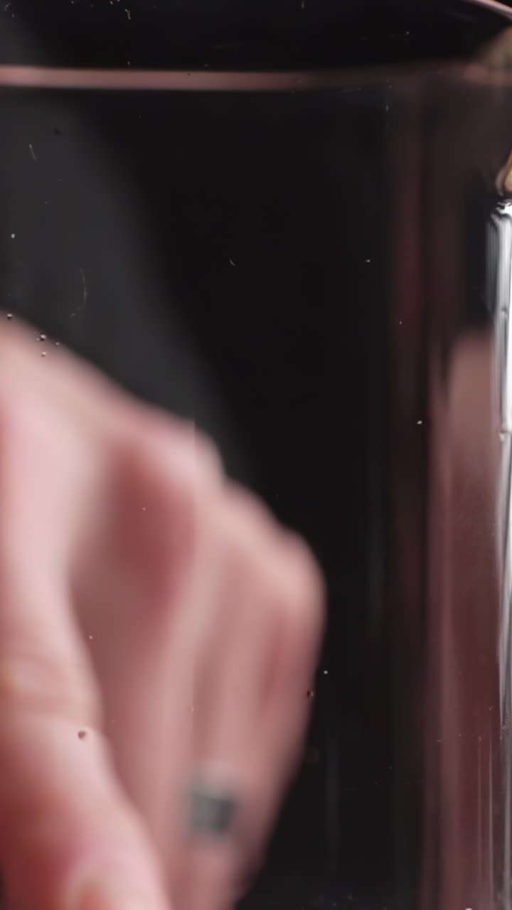 Hand touching a glass of water