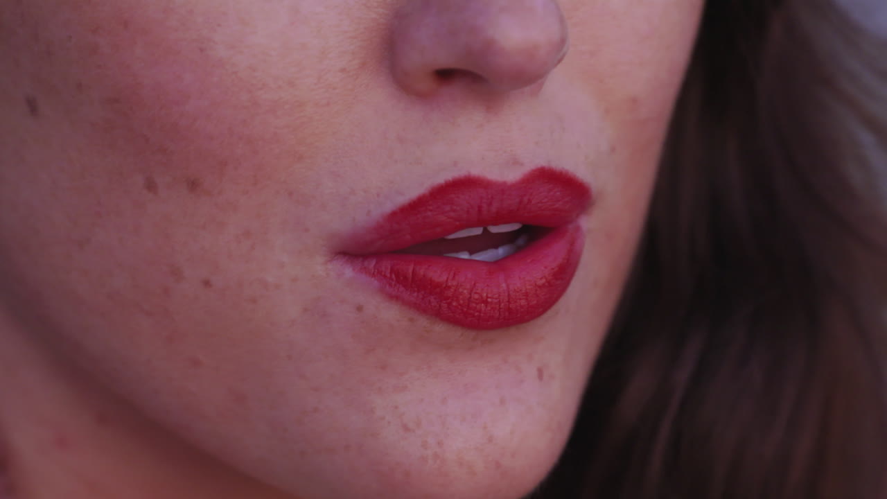 primer plano de los labios rojos y brillantes de una mujer joven y glamorosa