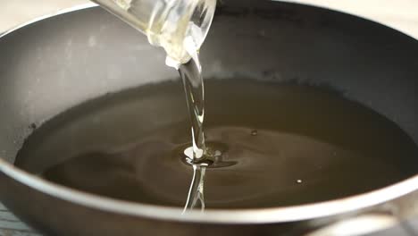 pouring cooking oil into a frying pan