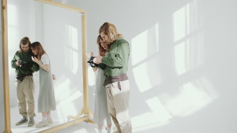 female model and photographer discussing photos on camera in studio