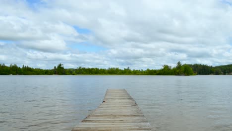 timelapse - dock on the lake in summer - puffy clouds and boats over the water