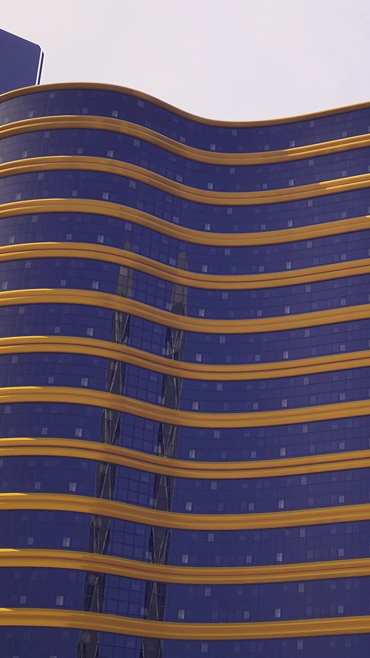 Diseño de edificio moderno con vidrio azul y líneas curvas en un entorno urbano