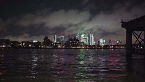 canary wharf view from greenwich london across the thames river at night near pier.