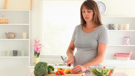 Happy-pregnant-woman-chopping-vegetables