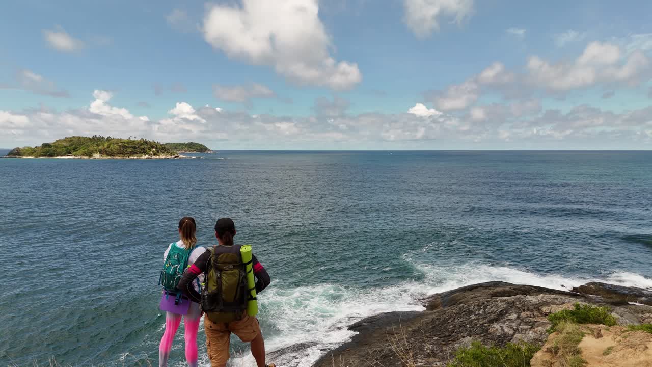 Couple Hiking on the Cliff by the Ocean