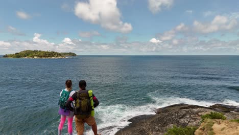 couple hiking on the cliff by the ocean
