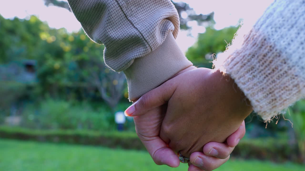 pareja cogida de la mano en el parque por amor