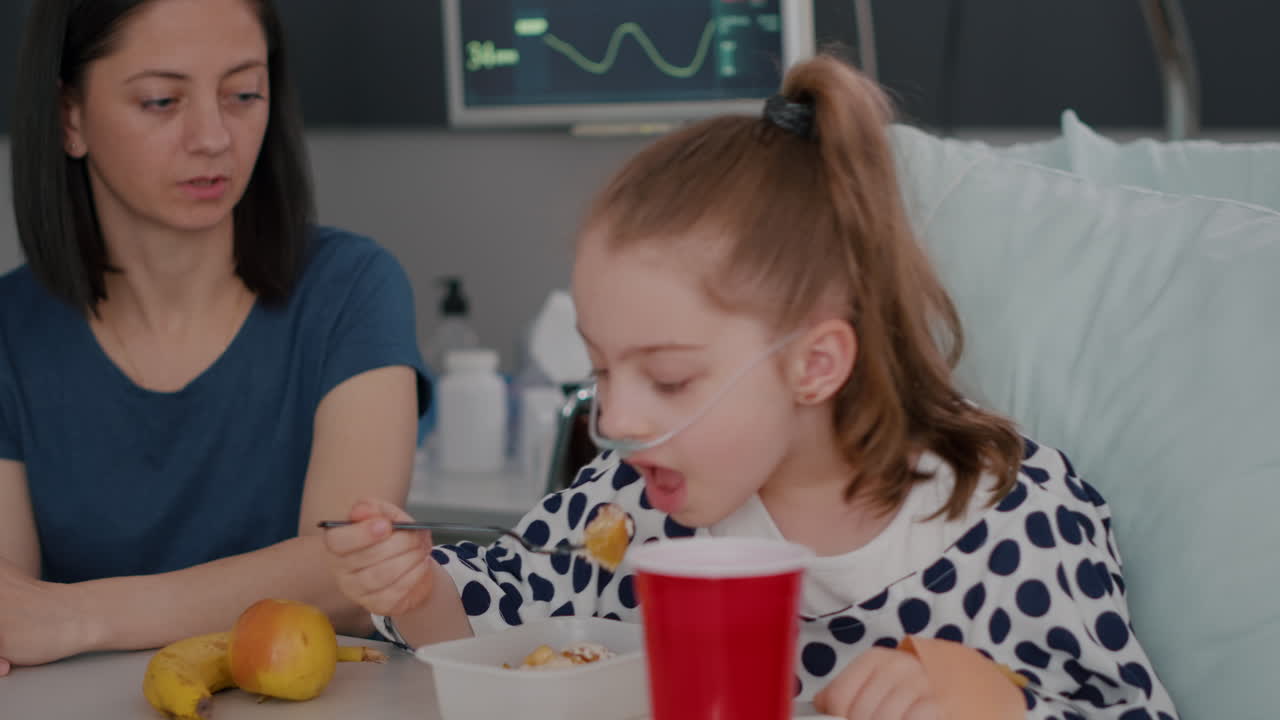 Mother standing with sick girl while eating healthy food breakfast during sickness expertise