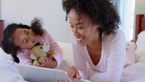 Front-view-of-black-mother-and-daughter-using-digital-tablet-at-comfortable-home-4k