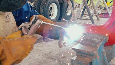 Professional-welder-of-heavy-industry,-in-a-factory-begins-to-weld-a-pipe,-Slow-motion