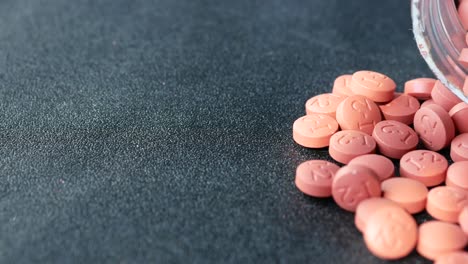 pink pills on dark surface