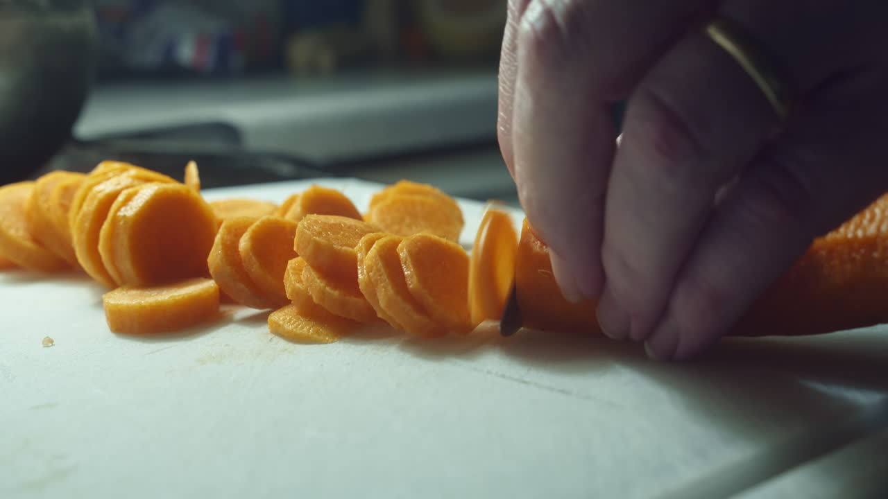 당근을 칼로 손으로 얇게 썰어 클로즈업