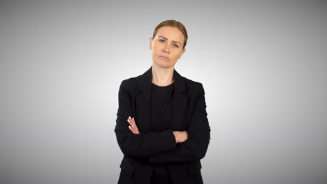 una mujer de negocios enojada y seria cruzando los brazos con un fondo de estudio blanco