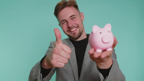 happy young business man putting one dollar cast inside piggybank, investment, deposit, success