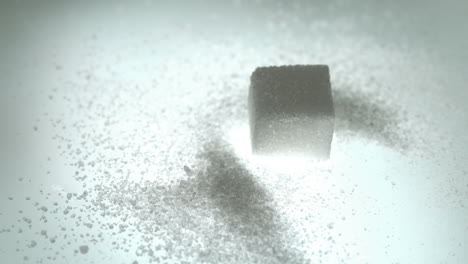 cubo de azúcar cayendo sobre una pila de azúcar en polvo