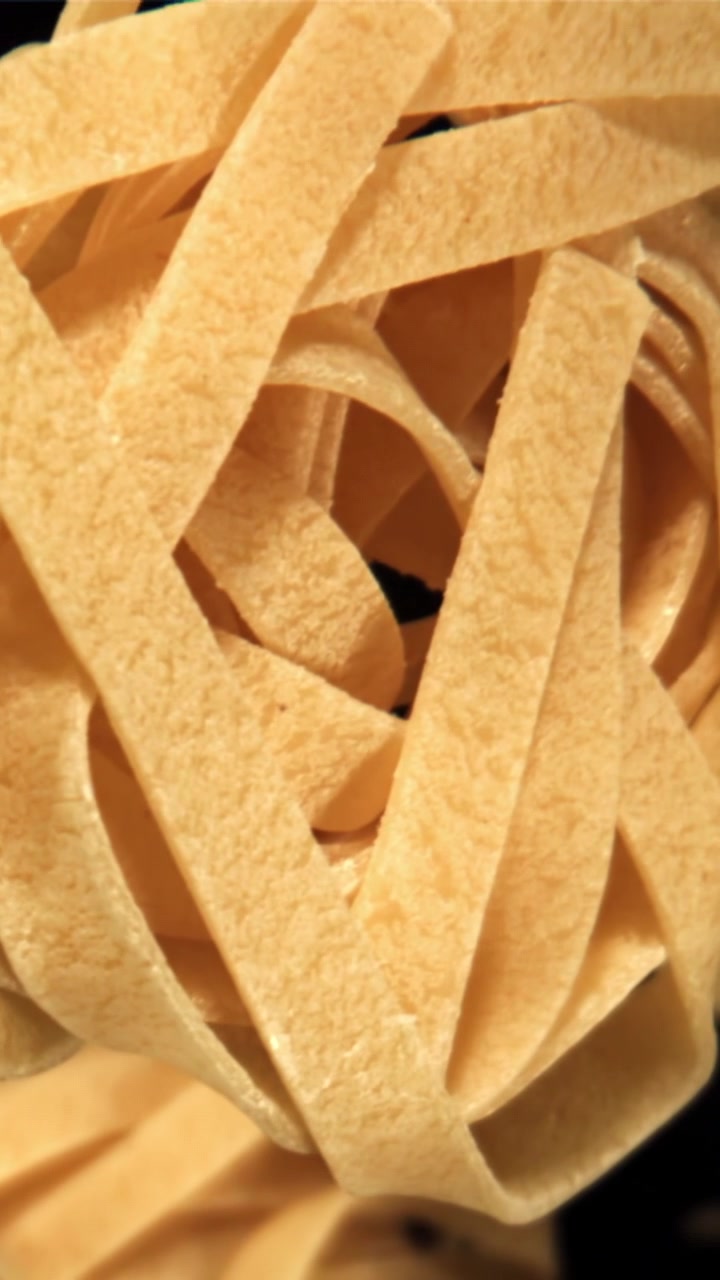 Primo piano con zoom indietro di nidi di tagliatelle secche