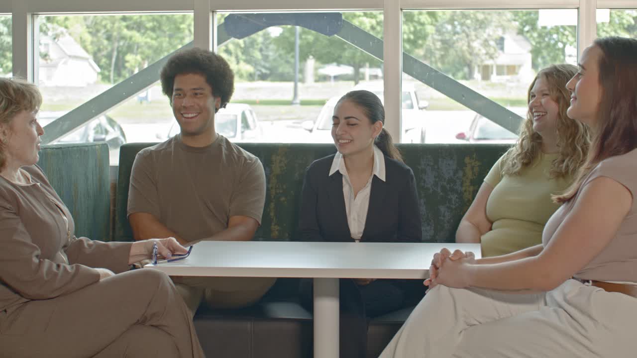 왼쪽에서 오른쪽으로 가까운 비디오를 가진 네 명의 젊은 노동자들과의 사무실 회의