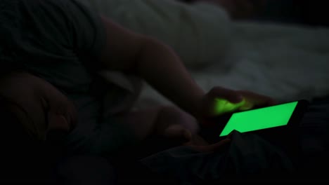 person using phone in bed at night