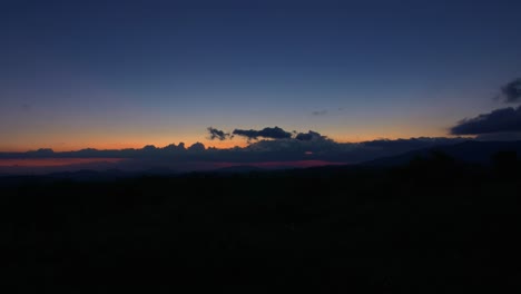 time lapse, clouds moving through sky at sunset to dusk, horizon and mountains, vietnam