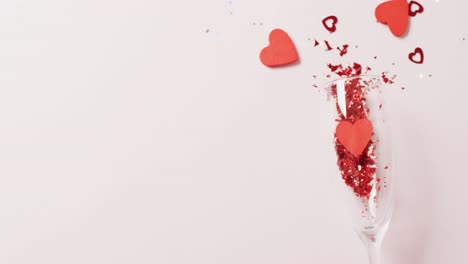 Video-Von-Champagnerglas,-Das-Rote-Herzformen-Verschüttet,-Auf-Weißem-Hintergrund-Mit-Kopierraum