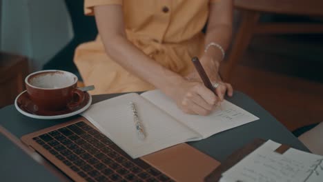 woman writing in a cafe