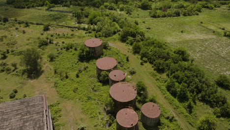 rusty round tanks on green field outside an industrial chemical factory in khashuri, georgia