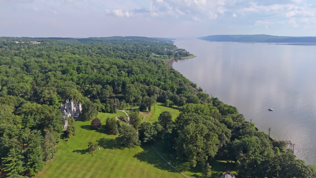 Green coastline with villas and castle house at Hudson River. Sunny day in summer. Aerial flyover shot. Greenburgh, tarrytown, USA. Wide shot