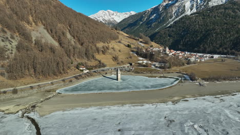 Drone-Dolley-Tiro-De-La-Iglesia-Hundida-De-Graun-En-Un-Lago-Congelado-En-Italia