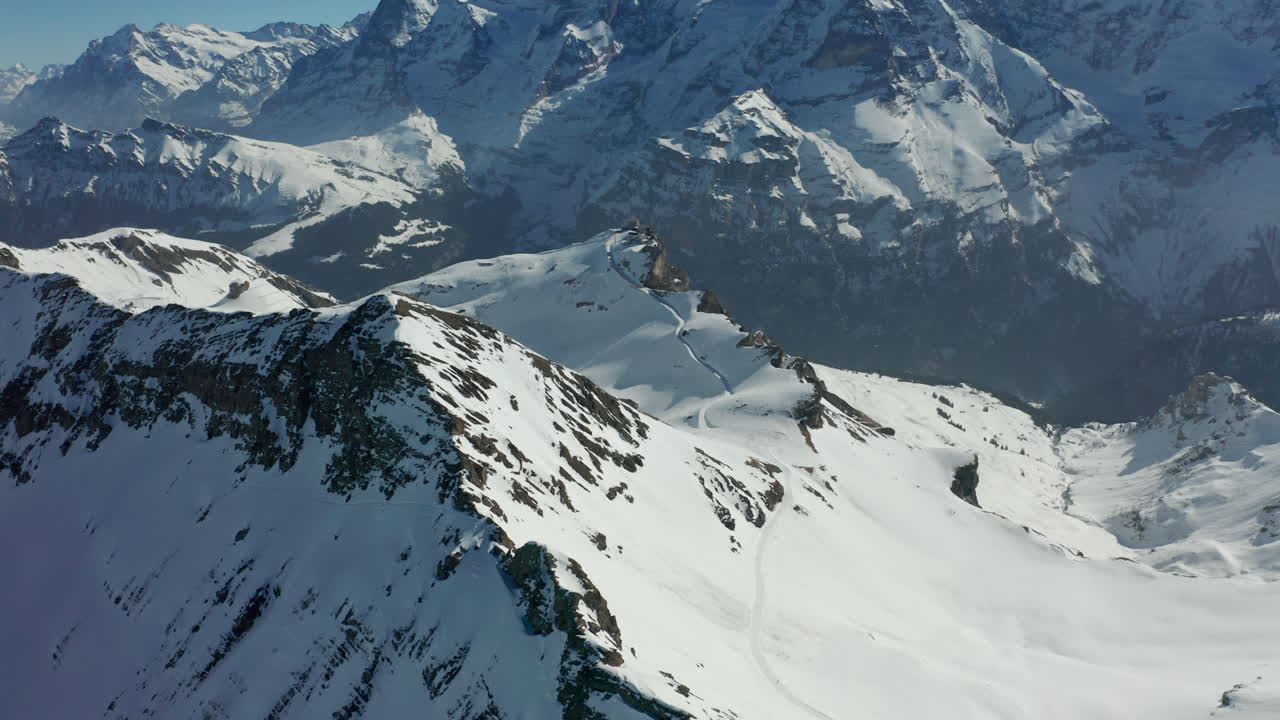 Splendida veduta aerea di bellissime montagne coperte di neve contro un cielo azzurro limpido