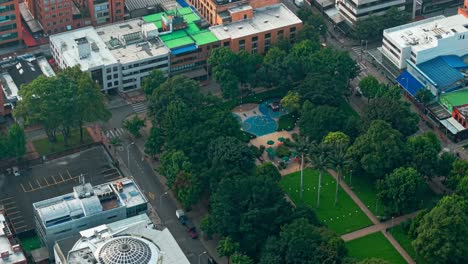 a park with playground, trees, and surrounding urban buildings in bogotá, aerial view