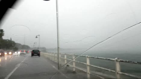 on the road while raining, next to the sea