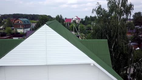 house exterior with green roof and white siding