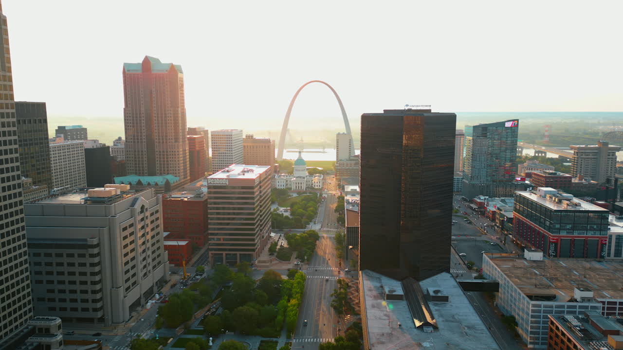 San Luis (EE. UU.), 14 de agosto de 2025: La luz del sol poniente ilumina el paisaje de San Luis, Misuri (EE. UU.). Vídeo aéreo sobre la carretera de varios carriles y el parque verde.