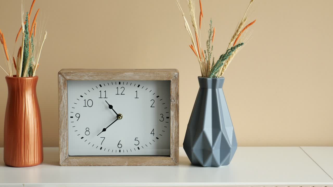 un reloj y jarrones en una mesa