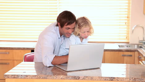 Padre-E-Hijo-Sonrientes-Usando-Una-Computadora-Portátil