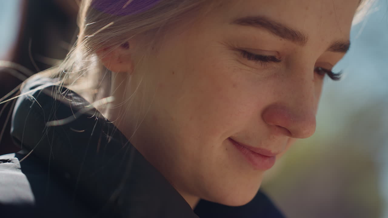 Улыбающаяся блондинка на открытом воздухе, нежный ветер, портрет счастливой блондинки под солнцем с ветерком, крупный план жизнерадостной блондинки на открытом воздухе с солнечным светом на лице и развевающимся ветром