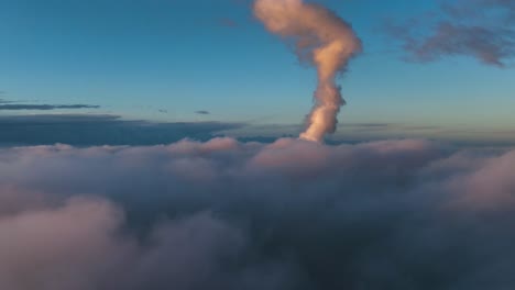 smog from industrial factory rise through clouds - drone view above clouds