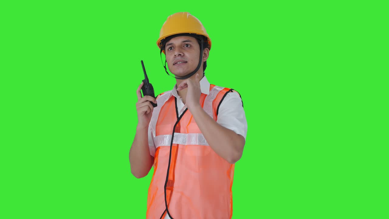 Happy Indian architect giving instructions on walkie talkie Green screen
