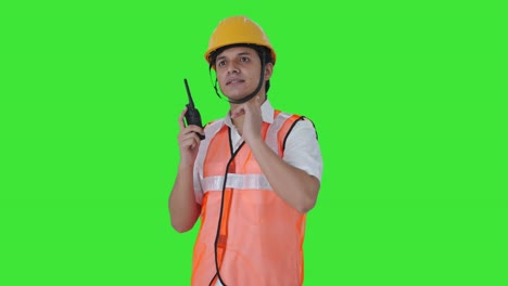 arquitecto indio feliz dando instrucciones en la pantalla verde del walkie talkie