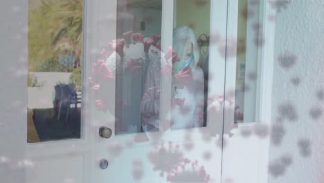 animation of virus cells over senior caucasian woman taking package with face mask