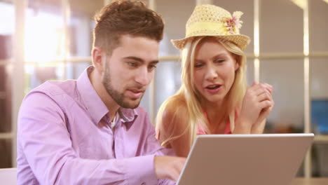 Smiling-casual-business-workers-working-with-laptop