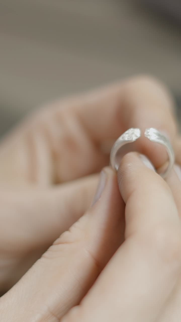 Close-up of Hands Holding a Silver Ring