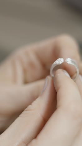 close-up of hands holding a silver ring