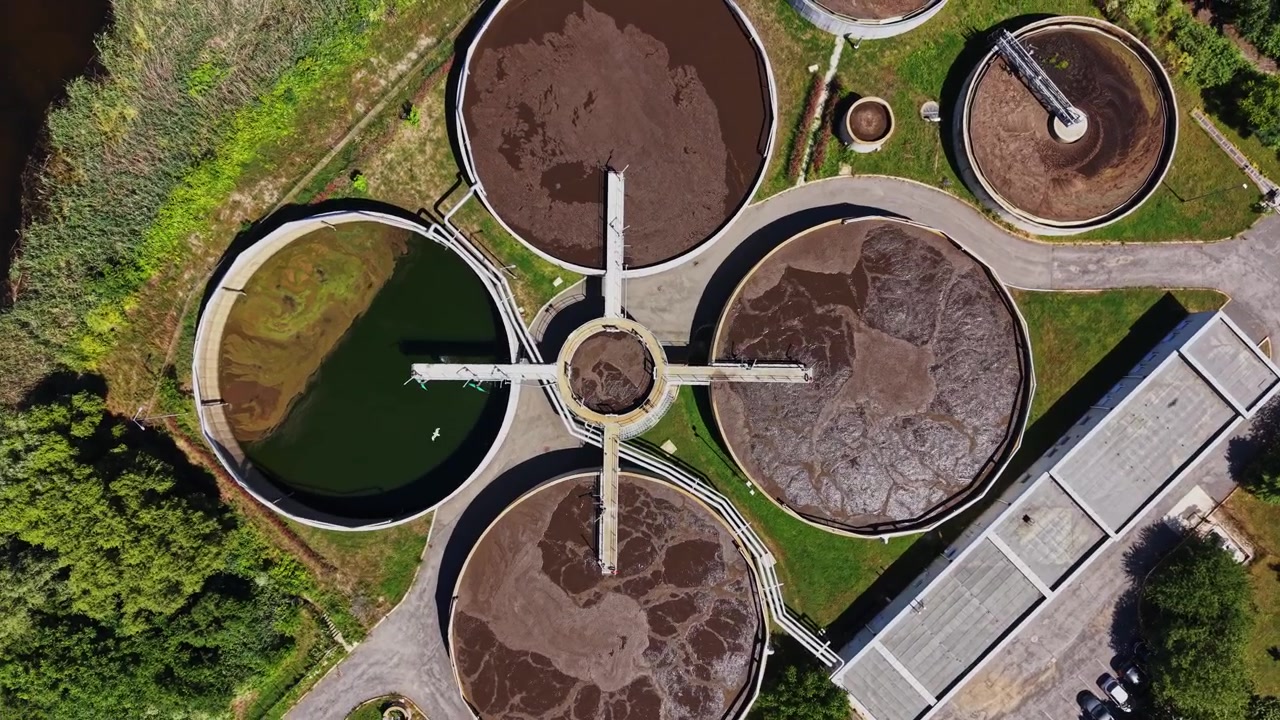 Planta de tratamiento de aguas residuales ubicada en una zona verde cerca de espacios urbanos
