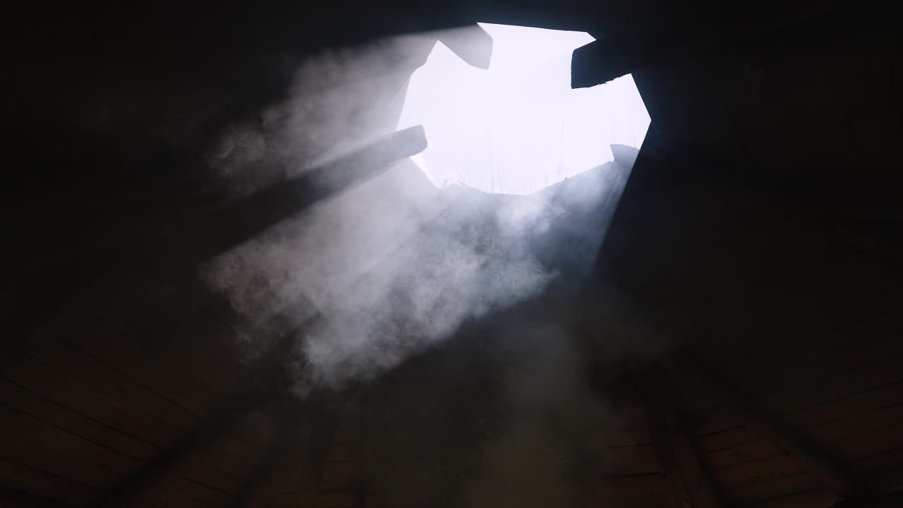 Interior View of a Wooden Hut with Smoke and Sunlight