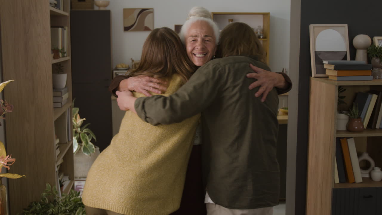A grandmother hugging her grandchildren in her home