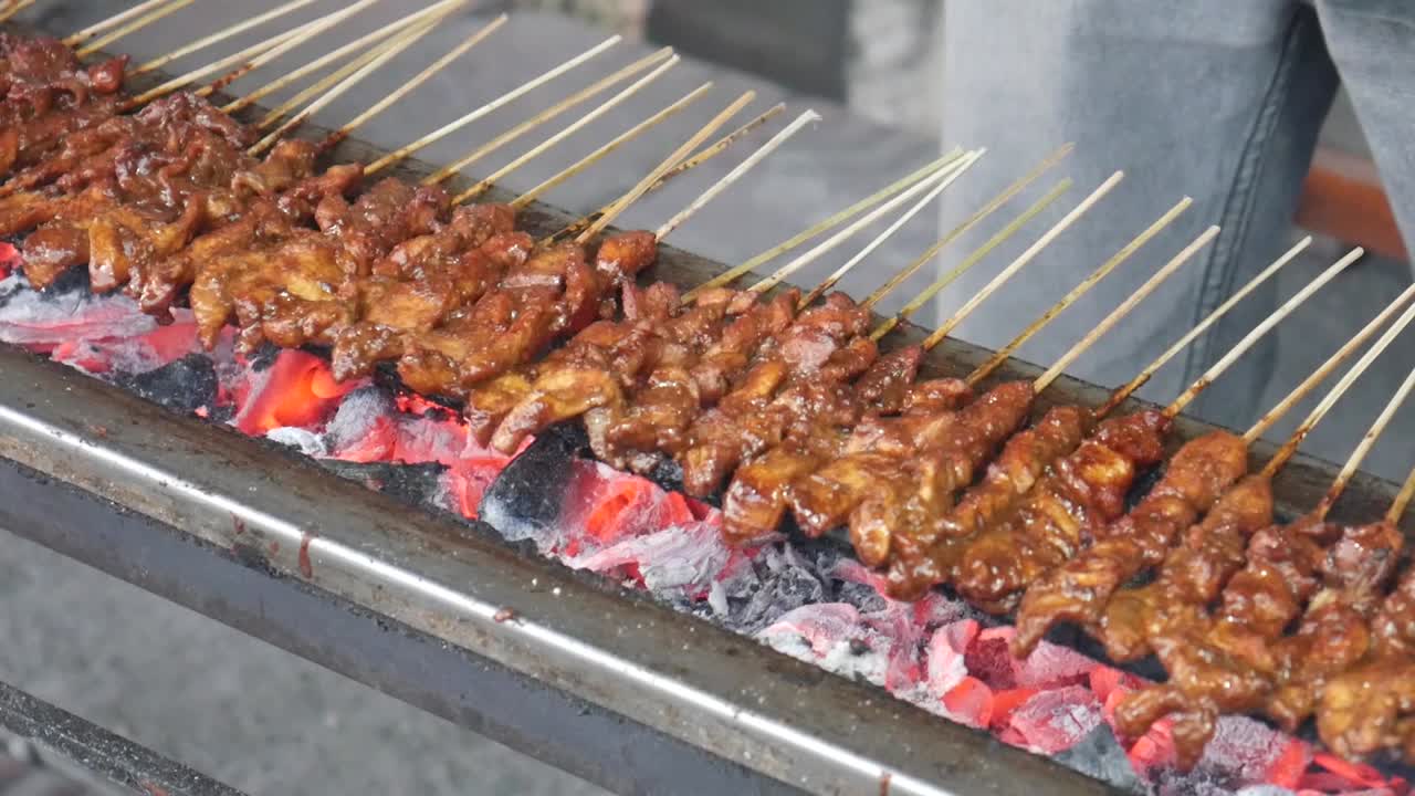 Chicken satay cooking process. Grilled chicken over coals. Indonesian street food