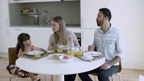 parents couple and little girl having breakfast together